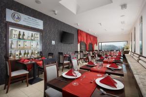 Hotel Slunný Dvůr في جيسينيك: غرفة طعام مع طاولات وكراسي بمناديل حمراء