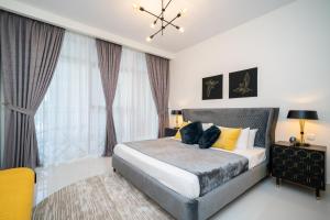 a bedroom with a bed and a large window at HiGuests - Chic Apt with Balcony and Pool near Burj Khalifa in Dubai