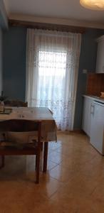 a kitchen with a table in front of a window at Antal Apartmanok in Zalakaros