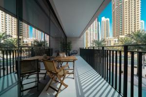 a balcony with tables and chairs and a view of the city at HiGuests - Chic Apt with Balcony and Pool near Burj Khalifa in Dubai