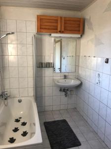 La salle de bains est pourvue d'un lavabo et d'une baignoire. dans l'établissement Ferienwohnung Am Schaumberg, à Tholey