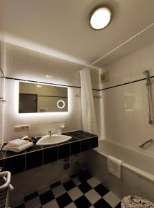 a bathroom with a sink and a tub and a mirror at City Apartment in Chemnitz