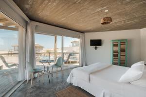 um quarto com uma cama e vista para o oceano em MarAdentro Apart Hotel & Suites em Punta Del Diablo