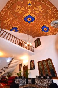 a living room with a ceiling with blue and golditures at Villa Marinaa in Puducherry