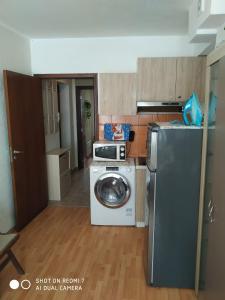 a kitchen with a washing machine and a refrigerator at Апартмент Паисий 15 in Varna City