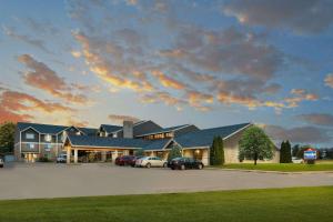 a large house with cars parked in a parking lot at AmericInn by Wyndham Valley City Conference Center in Valley City