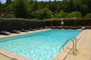 een groot zwembad met stoelen in een resort bij Résidence Les Aulnes in Porto-Vecchio