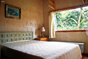 Un dormitorio con una cama grande y una ventana en Bosque Peralta Ramos Cabañas Nalu 1 en Mar del Plata