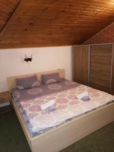 a bedroom with a large bed with a wooden ceiling at Mountain house Campari in Mavrovo