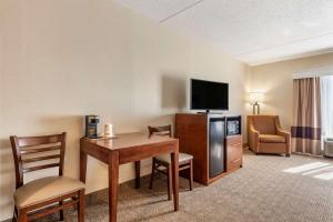 a hotel room with a desk and a television at Comfort Inn & Suites in Morehead