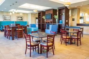 a restaurant with tables and chairs and a bar at Comfort Inn & Suites Plainville-Foxboro in Plainville