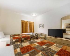 a hotel room with two beds and a flat screen tv at Rodeway Inn in Watsonville