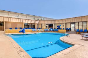 a large pool with blue chairs and tables at Comfort Inn Denver Central in Denver