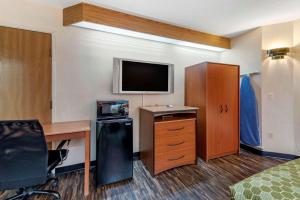 a hotel room with a bed and a desk and a television at Econo Lodge North Academy in Colorado Springs +11 photos