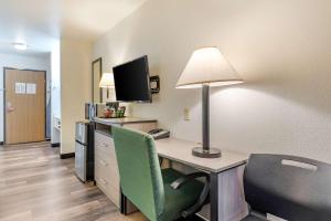 a hotel room with a desk with a computer and a lamp at Econo Lodge Pueblo North in Pueblo