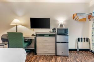 a hotel room with a desk with a computer and a tv at Econo Lodge Pueblo North in Pueblo