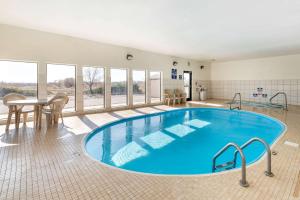 a large pool in a room with a table and chairs at Econo Lodge Pueblo North in Pueblo