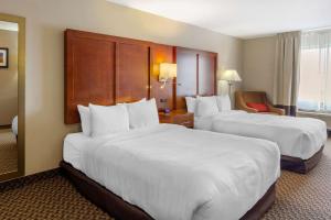 una habitación de hotel con 2 camas y una silla en Comfort Inn & Suites Sterling, en Sterling