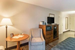 Habitación de hotel con cama, mesa y TV. en Econo Lodge, en Grand Junction