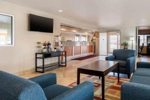 a living room with two blue chairs and a table at Quality Inn & Suites Limon in Limon
