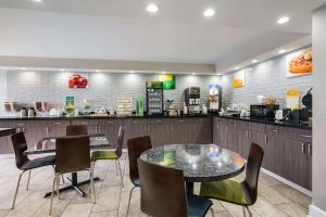 a restaurant with a table and chairs and a counter at Quality Inn Greenville near University in Greenville