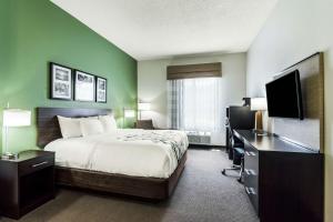 a hotel room with a bed and a desk and a television at Sleep Inn & Suites Smithfield near I-95 in Smithfield