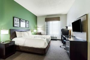 Sleep Inn & Suites Smithfield near I-95 في سميثفيلد: غرفة فندقية فيها سرير ومكتب وتلفزيون