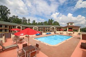 einen Pool in einem Resort mit Tischen und Stühlen in der Unterkunft Econo Lodge Inn And Suites - Pilot Mountain in Pilot Mountain