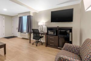 a living room with a couch and a desk with a television at Quality Inn & Suites in Lincoln
