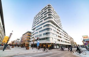 a tall building with people crossing a street in front of it at Apartment City in Oulu