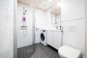 a bathroom with a shower and a washing machine at Apartment City in Oulu +21 photos