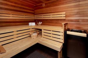 a sauna with wooden walls and a bench and a bucket at Aparthotel Hornigold "W Zielonej Kamienicy" in Katowice