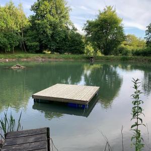 a dock sitting in the middle of a lake at Farm Stay Happy Dogs Ranch in Veberöd