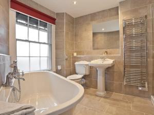 a bathroom with a tub and a toilet and a sink at The Angel Inn - The Inn Collection Group in Bowness-on-Windermere