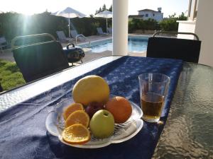 un plato de fruta en una mesa con un vaso de cerveza en Mariandy Villa 2, en Bahía de Coral