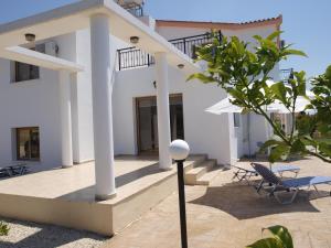 uma casa branca com colunas brancas e um pátio em Mariandy Villa 2 em Coral Bay