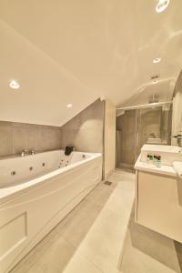 a white bathroom with a tub and a sink at Selini Hotel İstanbul Airport in Istanbul