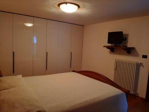 a bedroom with a bed and a flat screen tv at La Tanière in Morgex