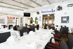 a dining room with white tables and chairs at Hotel El Ancla in Calahonda