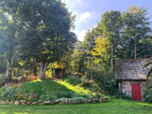 a garden with a red door and a building at Farm Stay Happy Dogs Ranch in Veberöd