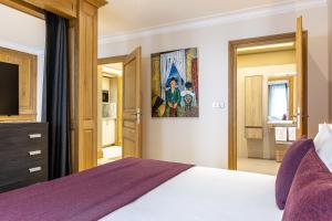 a bedroom with a large bed and a tv at Les Jardins de St Cloud in Saint-Cloud