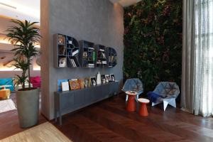 a lobby with two chairs and a plant at Pullman Sharjah in Sharjah