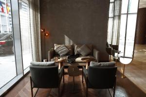 a living room with a couch and a table and chairs at Pullman Sharjah in Sharjah