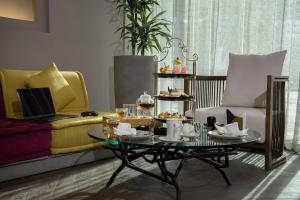 a living room with a coffee table with food on it at Pullman Sharjah in Sharjah