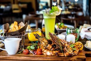 a table with a plate of food and a drink at Pullman Sharjah in Sharjah