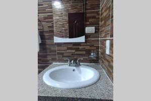 a white sink in a bathroom with a brick wall at Apartamento de una habitacion ,con wifi Luz 24/7 in Jarabacoa