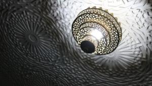 a light hanging from the ceiling of a room at Dar Habache in Marrakesh +133 photos