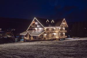 a large house with lights on it at night at Penzion Katarina in Ždiar