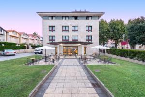 洛乌Hospedium Hotel Sky Blu Loiu的一座前面有桌椅的建筑物