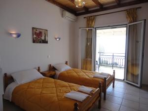 two beds in a room with a balcony at Villa Elli Panoramic View in Ipsos